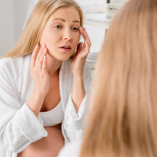 Pregnant woman gently caring for skin prone to acne
